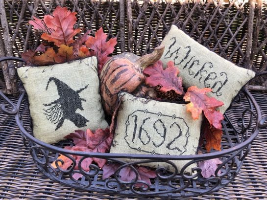 Photo of finished Bewitched pillow tuck set in a wire basket filled with Autumn leaves and other Fall season decor